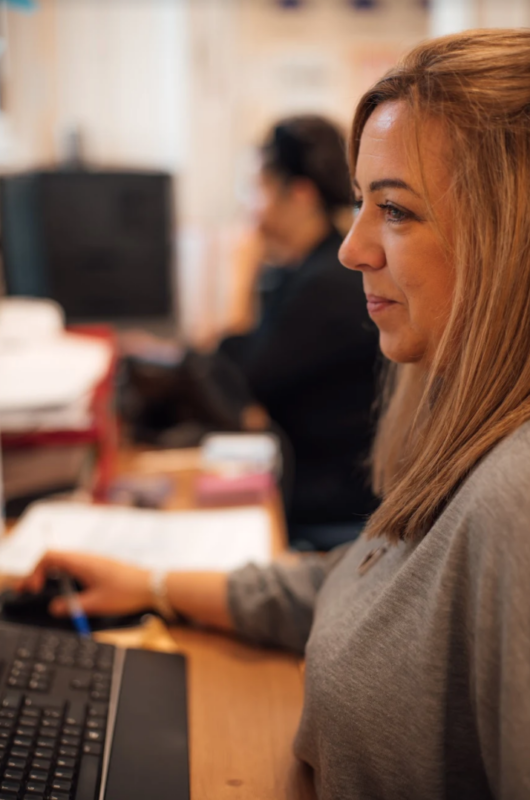 A member of the Arch team at work, sitting a desk looking at computer