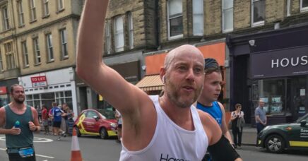 Runner waving while running in the 2021 Brighton Marathon