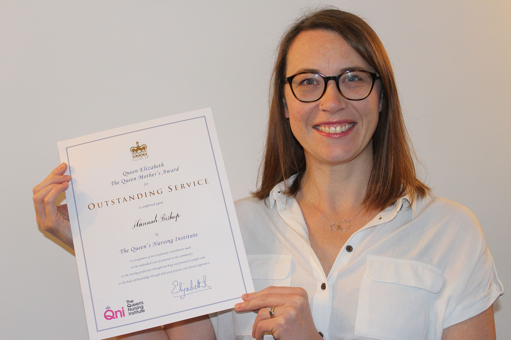 ANP Hannah Bishop holding up her QNI award certificate