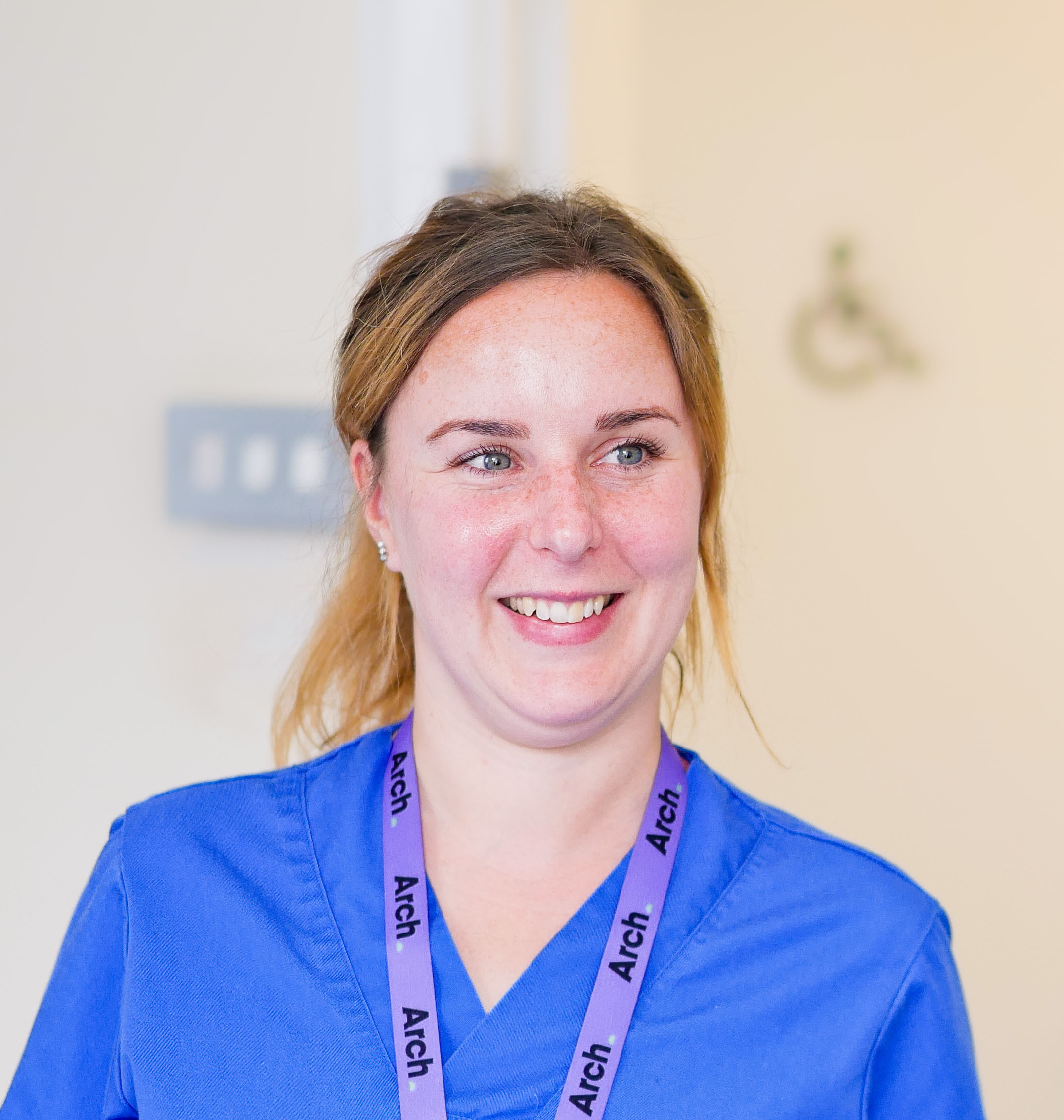 Hannah Palmer, Arch Nurse, in scrubs, smiling