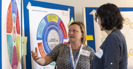Mary Darking talking through a system map from Common Ambition, to a conference delegate.