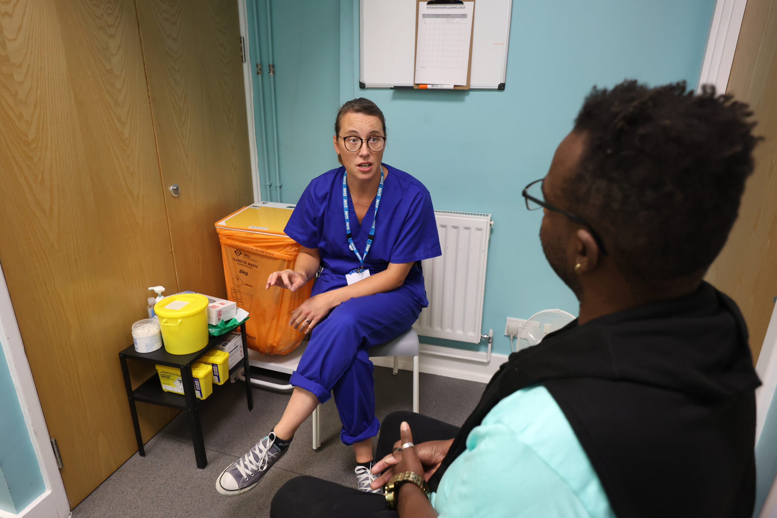 A patient and nurse talking to each other in a consultation room