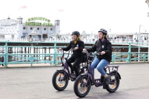 Arch Healthcare Outreach team out and about in Brighton on their new E-Bikes, cycling in front of the palace pier.