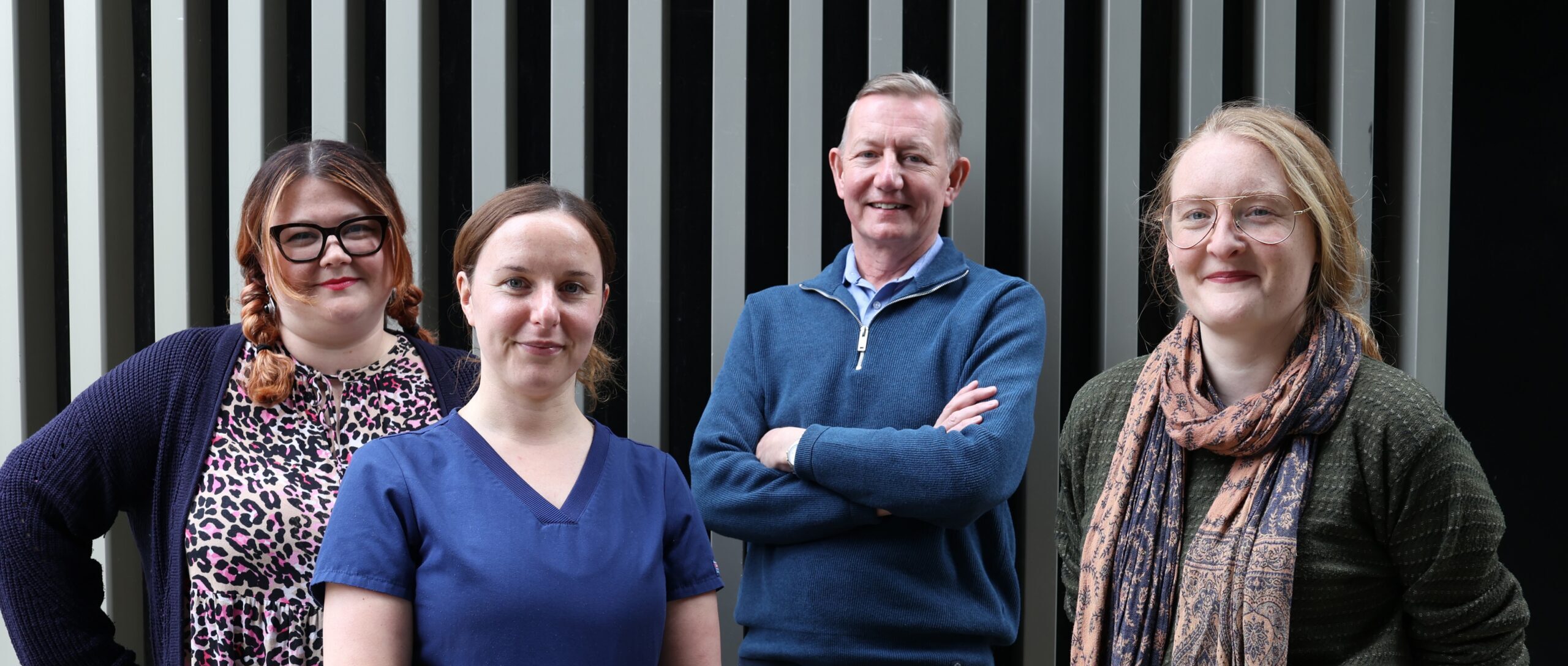 4 members of the hospital inreach team, smiling at the camera in a posed shot.